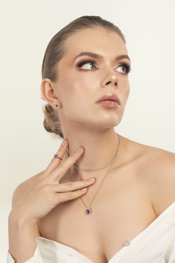 a woman looking up with a necklace and earrings