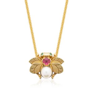 a gold bee necklace with a pearl and a ruby stone